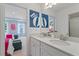 Dual sink bathroom with white cabinets and decorative mirrors leading to a beautifully decorated bedroom at 205 Haverling Pass, Hampton, GA 30228