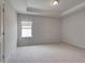 Bedroom with neutral carpet, tray ceiling and a window for natural light at 205 Haverling Pass, Hampton, GA 30228