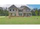 Charming home with gray and brick exterior, set on a spacious lawn with beautiful, mature trees at 205 Haverling Pass, Hampton, GA 30228