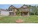 Attractive two-story home showcasing a well-maintained lawn and stylish brick exterior at 205 Haverling Pass, Hampton, GA 30228