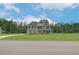 Inviting two-story home featuring a well-manicured lawn and gray and brick exterior at 205 Haverling Pass, Hampton, GA 30228