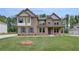 Charming two-story brick home featuring a well-manicured lawn and classic architectural details at 205 Haverling Pass, Hampton, GA 30228