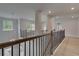 Upstairs hallway with wood floors and iron railing offers a view of modern hanging light at 205 Haverling Pass, Hampton, GA 30228