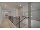Bright hallway with wood floors and wooden banister leads to a bathroom with recessed lights at 205 Haverling Pass, Hampton, GA 30228