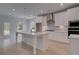 Bright kitchen features a large center island, white cabinets, stainless steel appliances, and hardwood floors at 205 Haverling Pass, Hampton, GA 30228