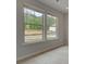 Bright living area with large windows and wood-look flooring, offering a serene view of the outdoors at 205 Haverling Pass, Hampton, GA 30228