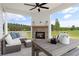 Covered patio with a brick fireplace, outdoor seating, and a view of the yard at 205 Haverling Pass, Hampton, GA 30228