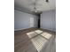 A cozy bedroom with light wood flooring, ceiling fan, and neutral walls at 91 Brookway Trce, Norcross, GA 30071