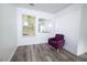 Bright bedroom featuring a window, stylish purple chair, and wood-look flooring at 1488 Cottage Way #32, Marietta, GA 30066