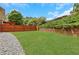 View of the green backyard with a wood fence and stone wall, ideal for outdoor enjoyment at 5143 Micaela Way, Duluth, GA 30096