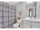 Neutral bathroom features a patterned shower curtain, white vanity, and tile flooring at 5143 Micaela Way, Duluth, GA 30096