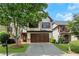 Charming home with a two-car garage, well-manicured lawn, beautiful landscaping, and a tree-lined front yard at 5143 Micaela Way, Duluth, GA 30096