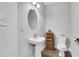 Powder room features pedestal sink, modern fixtures, and wood-look flooring at 5143 Micaela Way, Duluth, GA 30096