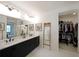 Bathroom featuring double vanity, large mirror, and walk-in closet with custom shelving at 518 Newstead Way, Woodstock, GA 30188