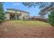 View of the backyard with a grassy lawn, patio with seating, and mature trees at 606 Discovery Ct, Acworth, GA 30102