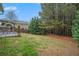 Expansive backyard featuring green lawn, mature landscaping, patio with seating, and stone fireplace at 606 Discovery Ct, Acworth, GA 30102