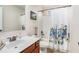 Bright bathroom featuring a shower and tub combo with floral curtain and updated vanity with a bronze faucet at 606 Discovery Ct, Acworth, GA 30102