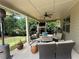 Covered outdoor patio with fireplace, television, ceiling fan, and comfortable seating area at 606 Discovery Ct, Acworth, GA 30102