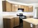 Well-lit kitchen featuring tan countertops, a gas range and ample cabinet space for storage at 6445 Marsham Dr, Atlanta, GA 30349