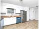 Bright kitchen features white cabinets, stainless steel refrigerator, and wood-look floors at 6884 Stephens Dr, Rex, GA 30273