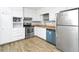 Well-lit kitchen with stainless steel appliances, white cabinets, and wood-look vinyl floors at 6884 Stephens Dr, Rex, GA 30273
