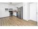 Open kitchen showcasing stainless steel appliances, white cabinetry, and wood grain floors at 6884 Stephens Dr, Rex, GA 30273