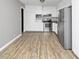Open concept kitchen featuring stainless steel appliances and modern wood-look floors at 6884 Stephens Dr, Rex, GA 30273