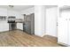 Well-lit kitchen with stainless steel appliances, white cabinets, and wood-look vinyl floors at 6884 Stephens Dr, Rex, GA 30273
