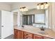 Well-lit bathroom with double sinks, granite countertops, and a large mirror, with tile flooring at 9942 Ashton Old Rd, Douglasville, GA 30135