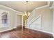 Bright living room featuring hardwood floors, an elegant chandelier, and a staircase with custom built-ins at 9942 Ashton Old Rd, Douglasville, GA 30135
