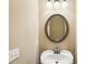Charming powder room features a pedestal sink, decorative mirror, and neutral walls at 9942 Ashton Old Rd, Douglasville, GA 30135