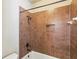 Tiled shower and bathtub combination with bronze fixtures, offering a modern and elegant bathing space at 9942 Ashton Old Rd, Douglasville, GA 30135