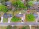 Aerial view of the property with a well-maintained lawn, mature trees, and proximity to neighborhood streets at 126 Washington St, Mcdonough, GA 30253