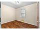 Standard bedroom with wood-look floors, a window with blinds, and painted walls at 126 Washington St, Mcdonough, GA 30253