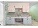 Kitchen sink and cabinets with retro tile and ample storage space at 126 Washington St, Mcdonough, GA 30253