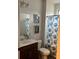 Bathroom features a white vanity, framed seashell art and a blue patterned shower curtain at 2660 Bateman Sw St, Powder Springs, GA 30127