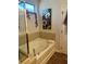 Bathroom showcasing a soaking tub, complemented by tile accents and a floral-themed artwork at 2660 Bateman Sw St, Powder Springs, GA 30127