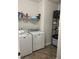 Practical laundry room with a washer, dryer, shelving, and storage space for convenience at 2660 Bateman Sw St, Powder Springs, GA 30127