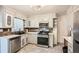 Traditional kitchen design features a stainless steel oven, white cabinets, stone countertops, and tile backsplash at 2875 Oldknow Nw Dr, Atlanta, GA 30318