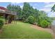 The backyard features a well-manicured lawn, a deck, and mature trees, creating a perfect outdoor retreat at 6597 River Island Dr, Buford, GA 30518