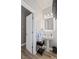 Well-lit powder room features a pedestal sink, modern lighting, and a decorative mirror at 6597 River Island Dr, Buford, GA 30518