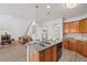 A kitchen boasts an island with a sink, wood cabinets and stylish pendant lighting at 6597 River Island Dr, Buford, GA 30518