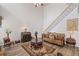 Open living room with staircase, alongside comfortable seating, an area rug and interior design at 6597 River Island Dr, Buford, GA 30518