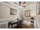 Cozy home office with a ceiling fan, decorative lamps, and a desk adorned with artwork and dark finishings at 6597 River Island Dr, Buford, GA 30518