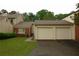 Property featuring a two-car garage, brick accents, well-maintained lawn, and mature trees at 4631 Calumet Cir, Duluth, GA 30096