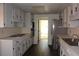 Galley kitchen featuring white cabinets, stainless steel appliances, and a dark hardwood floor at 4631 Calumet Cir, Duluth, GA 30096