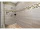 Modern tiled shower featuring pebble flooring, showerhead, and mosaic accents at 482 Pearl Cove Ct, Atlanta, GA 30350
