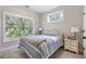 Bedroom with large windows offering serene outdoor views, with carpet flooring and a nightstand at 482 Pearl Cove Ct, Atlanta, GA 30350