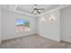 Bright and airy bedroom with tray ceiling, carpet, and view of a tree at 482 Pearl Cove Ct, Atlanta, GA 30350