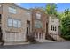 Three-story townhome with brick facade, individual garages, and landscaped entrance at 482 Pearl Cove Ct, Atlanta, GA 30350